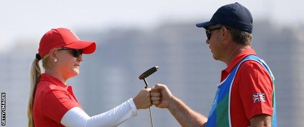 Charley Hull of Great Britain celebrates with her caddie Adam Woodward on the 18th hole during the second round of the Women's Individual Stroke Play golf on day 13 of the Rio Olympics