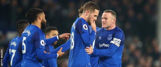 Gylfi Sigurdsson looks downcast while his Everton team-mates celebrate around him after his goal against former club Swansea City