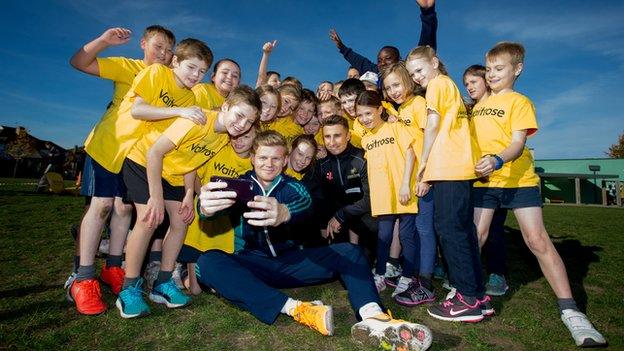 England's Sam Billings and James Taylor with school kids