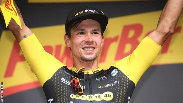 Primoz Roglic celebrates on the podium after winning stage 19