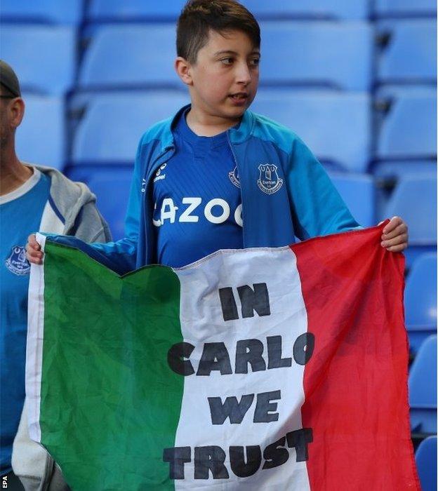 An Everton fan with an Italian flag saying 'in Carlo we trust' after their game against Wolves on 19 May