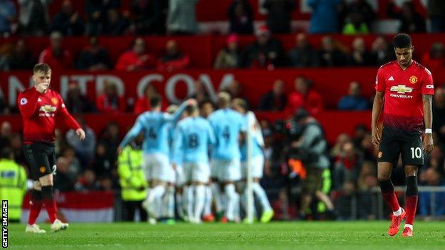 Man City players celebrate as Luke Shaw (left) and Marcus Rashford (right) look crestfallen