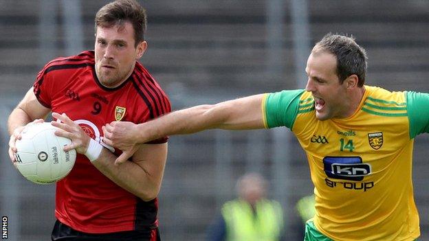 Down's Niall McGinley gets a tug from Donegal captain Michael Murphy at Clones