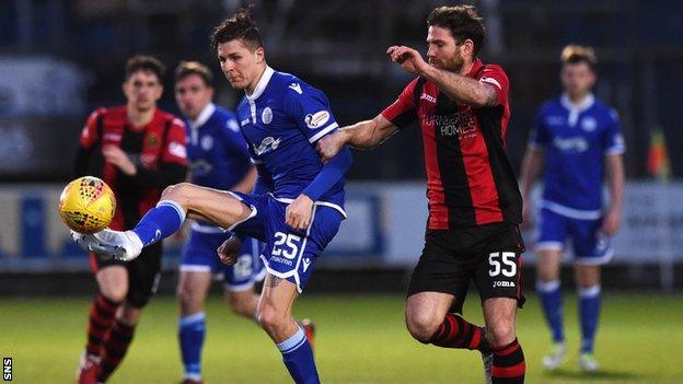 Queen of the South's Lyndon Dykes is challenged by Dumbarton's Craig Barr