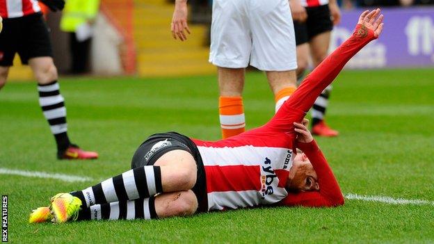 Robbie Simpson lies injured on the pitch