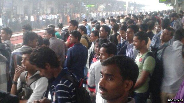 Commuters wait at a Mumbai railway station