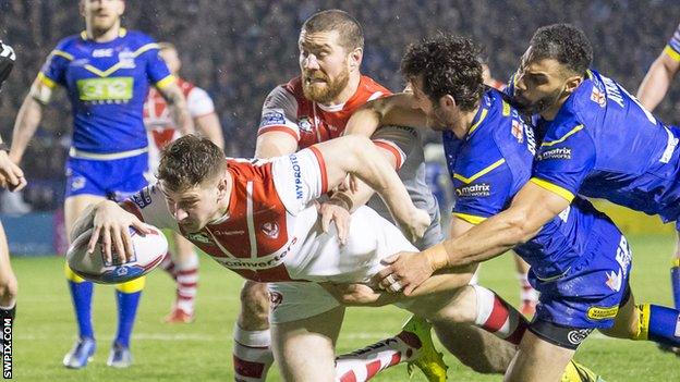 Mark Percival holds off a pair of Warrington tacklers to dive over for his first St Helens try of the night