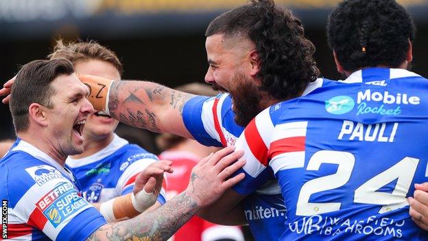 Wakefield's players celebrate after David Fifita (centre) scores against Salford