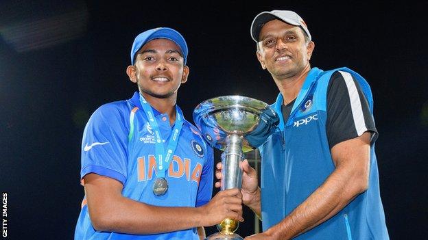 India captain Prithvi Shaw (left) and coach Rahul Dravid (right) pose with the trophy after their win in the ICC U19 Cricket World Cup Final