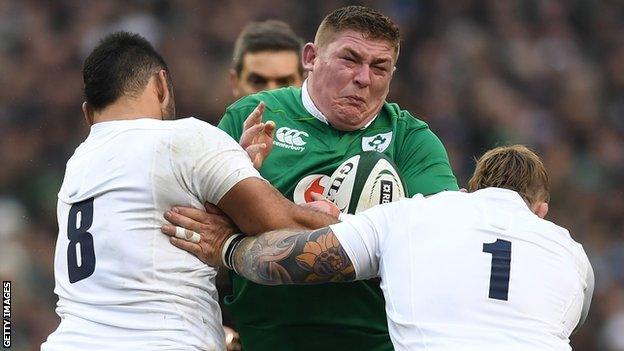 England's Nathan Hughes and Joe Marler tackle Ireland prop Tadhg Furlong un 2017 in Dublin