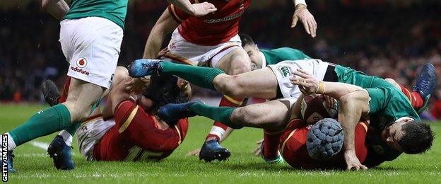 Johnny Sexton pins down Wales' Jonathan Davies just before being shown a yellow card in Cardiff