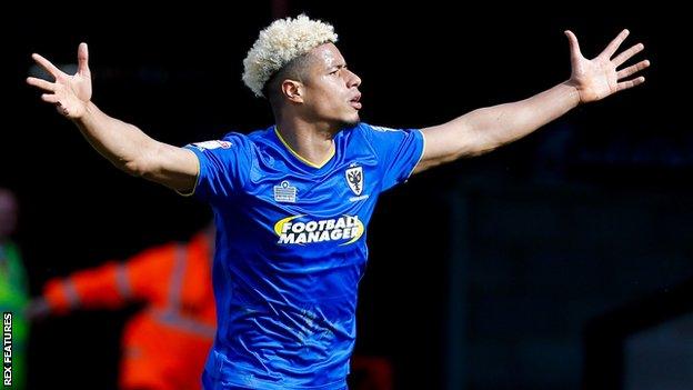 Lyle Taylor celebrates scoring a goal for AFC Wimbledon