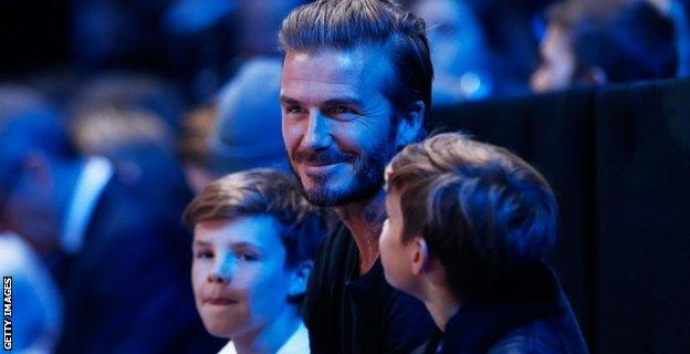 David Beckham (C) and his sons, Cruz (L) and Romeo (R) attend the men's singles semi final between Rafael Nadal of Spain and Novak Djokovic