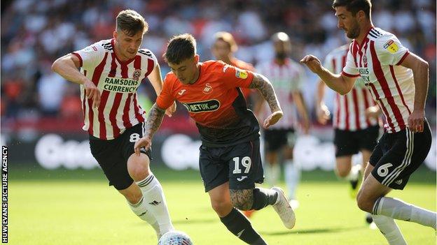 Barrie McKay of Swansea City gets between Lee Evans of Sheffield United and Chris Basham of Sheffield United