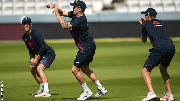 England player Jason Roy (c) takes a catch as Rory Burns (l) and Joe Root look on during England nets