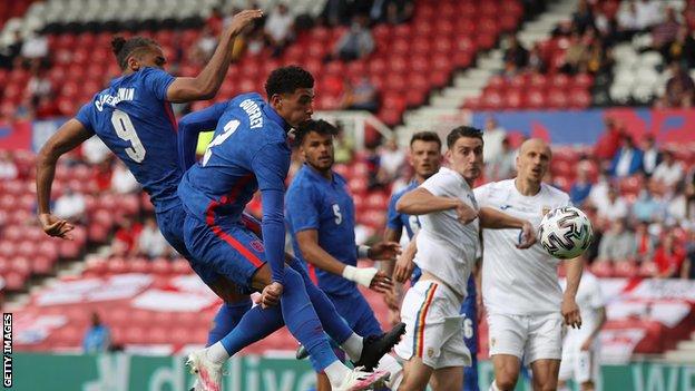 England's Dominic Calvert-Lewin and Ben Godfrey get up for a header in the box against Romania