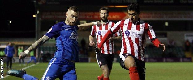 Lincoln City's Cameron Stewart challenges Peterborough United's Marcus Maddison