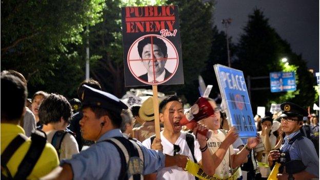 Police officers push back demonstrators as civic group members staged an anti-government rally outside of the National Diet in Tokyo on 15 July 2015 to protest against the controversial security bills which would expand the remit of the country's armed forces, approved by the ruling lawmakers at the parliamentary committee discussion.