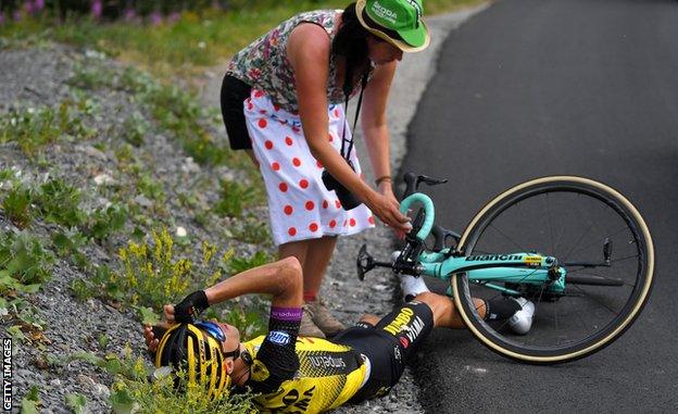 A Tour de France fan heps a stricken rider