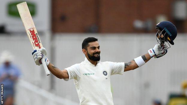 India captain Virat Kohli celebrates scoring a century by raising his bat and helmet