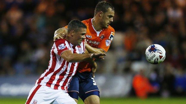 Luton's Luke Wilkinson battles for possession with Stoke striker Jonathan Walters