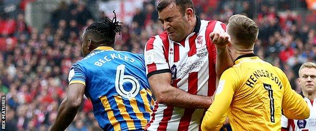 Lincoln's Matt Rhead collides with Shrewsbury goalkeeper Dean Henderson