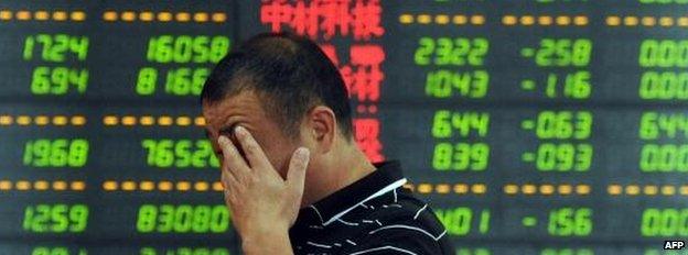 Man in front of share board in China