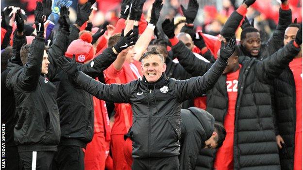 Canada head coach John Herdman leads his players in the Viking Clap as they celebrate