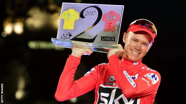 Chris Froome holds up a trophy to commemorate his wins at the 2017 Tour de France and Vuelta a Espana