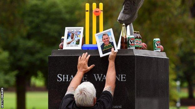 Tributes are laid at the Shane Wane statue at the MCG