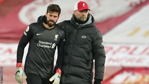 Jurgen Klopp with his arm round Alisson