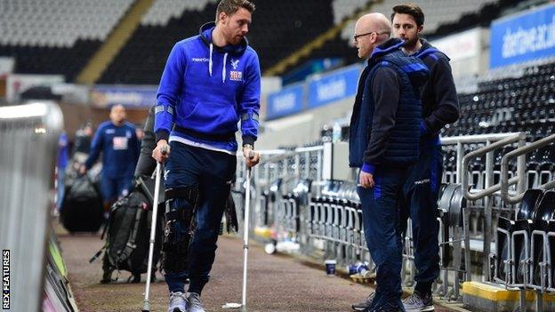 Connor Wickham of Crystal Palace walks out of the Liberty Stadium on crutches