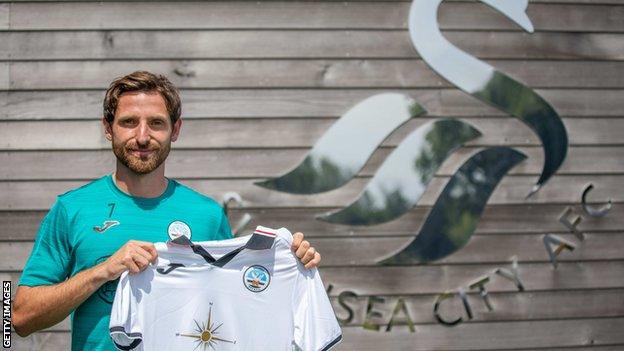 Joe Allen holds the Swansea shirt