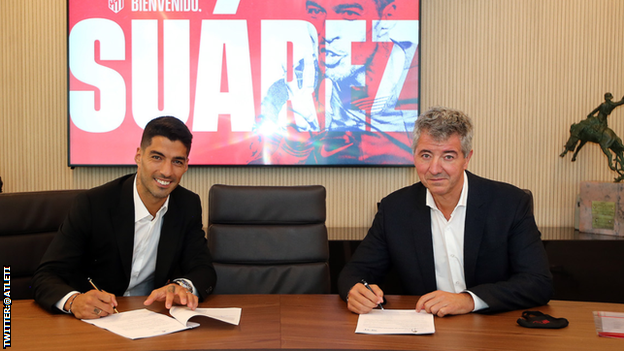 Luis Suarez signing his contract to join Atletico Madrid