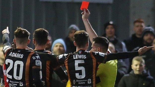 Referee Rob Hennessy sends off Derry's Sadou Diallo and Dundalk's Robbie McCourt at the Brandywell