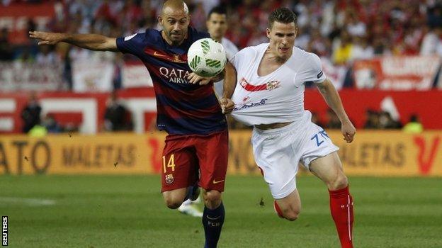 Javier Mascherano of Barcelona and Kevin Gameiro of Sevilla