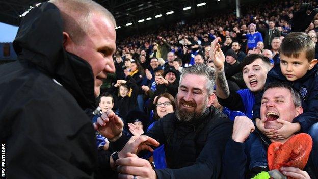 Pete Wild celebrates with Oldham's fans after their FA Cup win against Fulham at craven Cottage