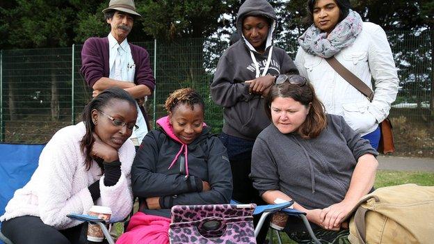 People watch a programme on an tablet