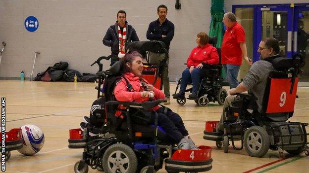 Wrexham co-chairmen Rob McElhenney and Ryan Reynolds watch a powerchair football session.