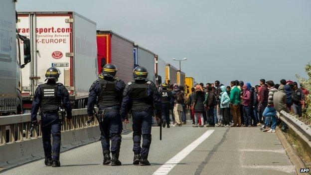 French riot police approach a crowd of migrants