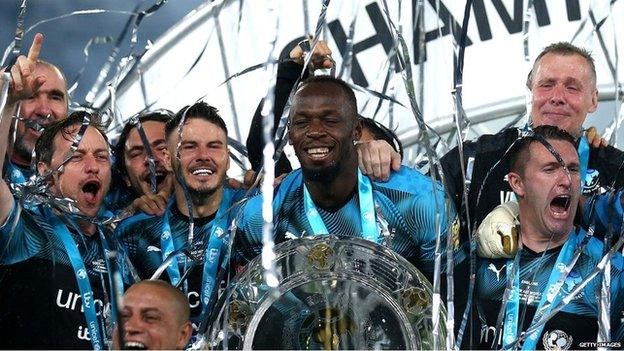 Usain Bolt with his Soccer Aid team and a trophy