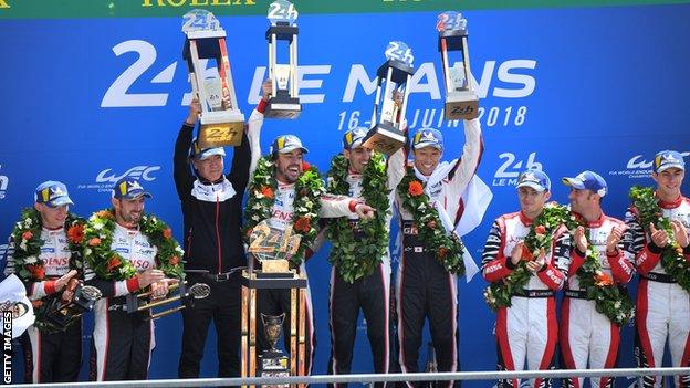 Toyota TS050 Hybrid LMP1's drivers Fernando Alonso of Spain (L), Kazuki Nakajima of Japan (R) and Sebastien Buemi of Switzerland (C), celebrate on the podium after winning