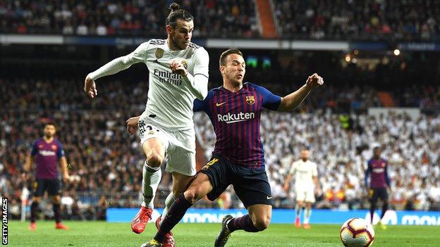 Real Madrid forward Gareth Bale (left) in action against Barcelona