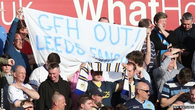 Leeds fans hold a banner reading "GFH out! Leeds fans in"