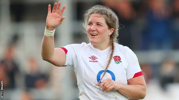 Poppy Cleall waves to the crowd after an England game