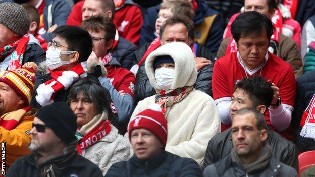 Fans uses masks at a Premier League game