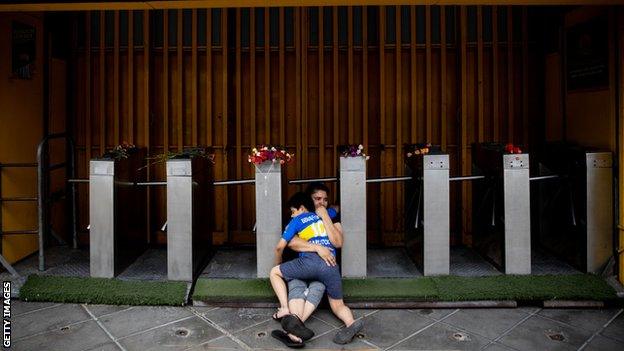 A mother and son mourn Maradona outside La Bombonera