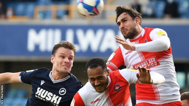 Millwall striker Matt Smith challenges Jordan Obita and Ryan Tafazolli for the ball