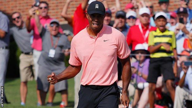 Tiger Woods celebrates making a putt