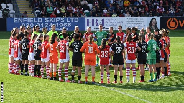 Everton and Arsenal players link arms before a recent WSL game